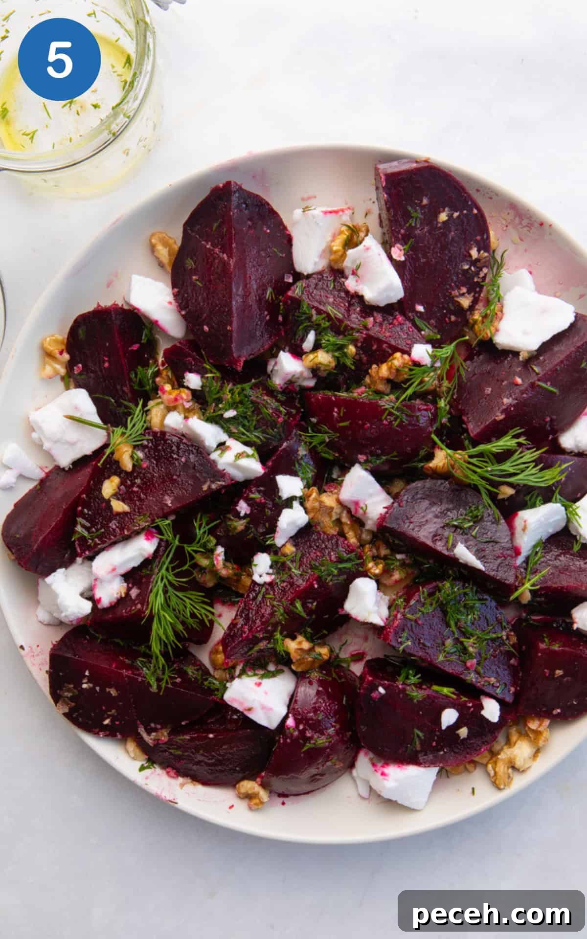 Vibrant Beetroot Salad with Citrus Vinaigrette 8 Beetroot in a large salad bowl mixed with walnuts, dill dressing, and feta.