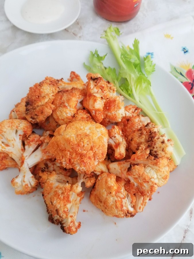 Crispy Air Fryer Buffalo Cauliflower Bites 7 Air Fryer Buffalo Cauliflower on white plate with celery