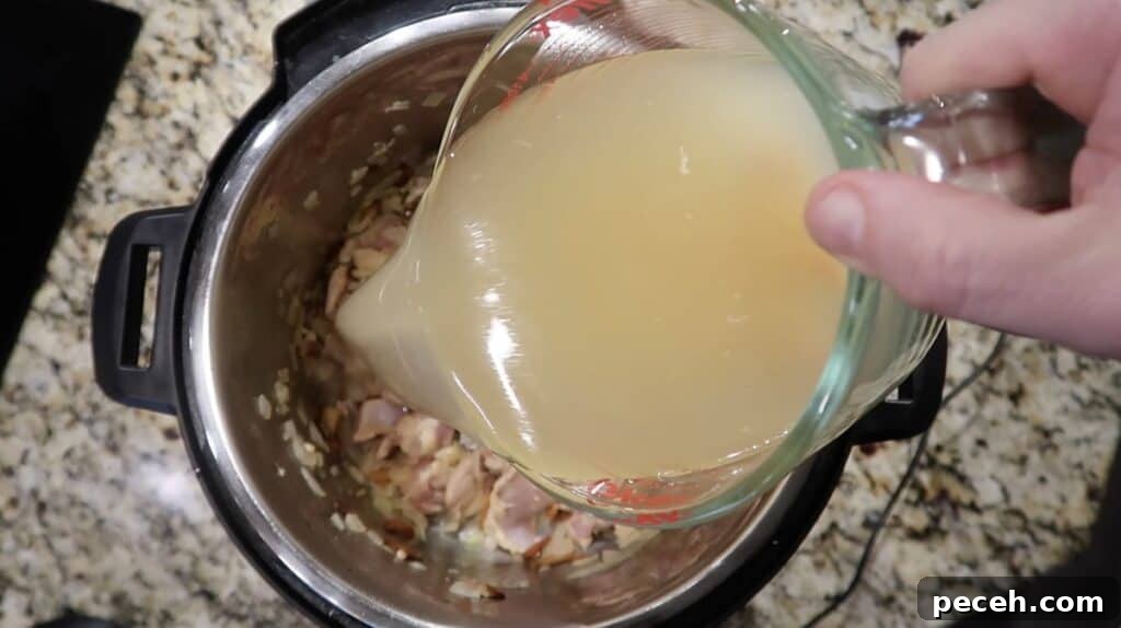 Creamy Garlic Chicken Pasta in the Instant Pot 17 Pouring broth in pot
