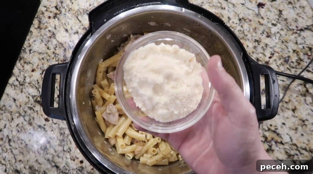 Creamy Garlic Chicken Pasta in the Instant Pot 21 Adding Parmesan to pot