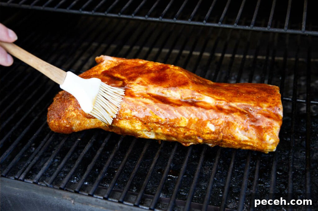 Smoked Pork Loin Recipe for Tender, Flavorful Meat 11 brushing the glaze on the pork loin