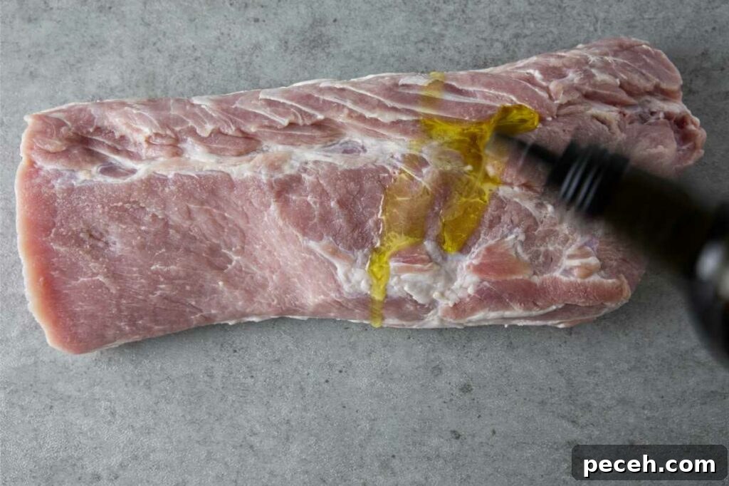 Smoked Pork Loin Recipe for Tender, Flavorful Meat 8 adding oil to the pork loin