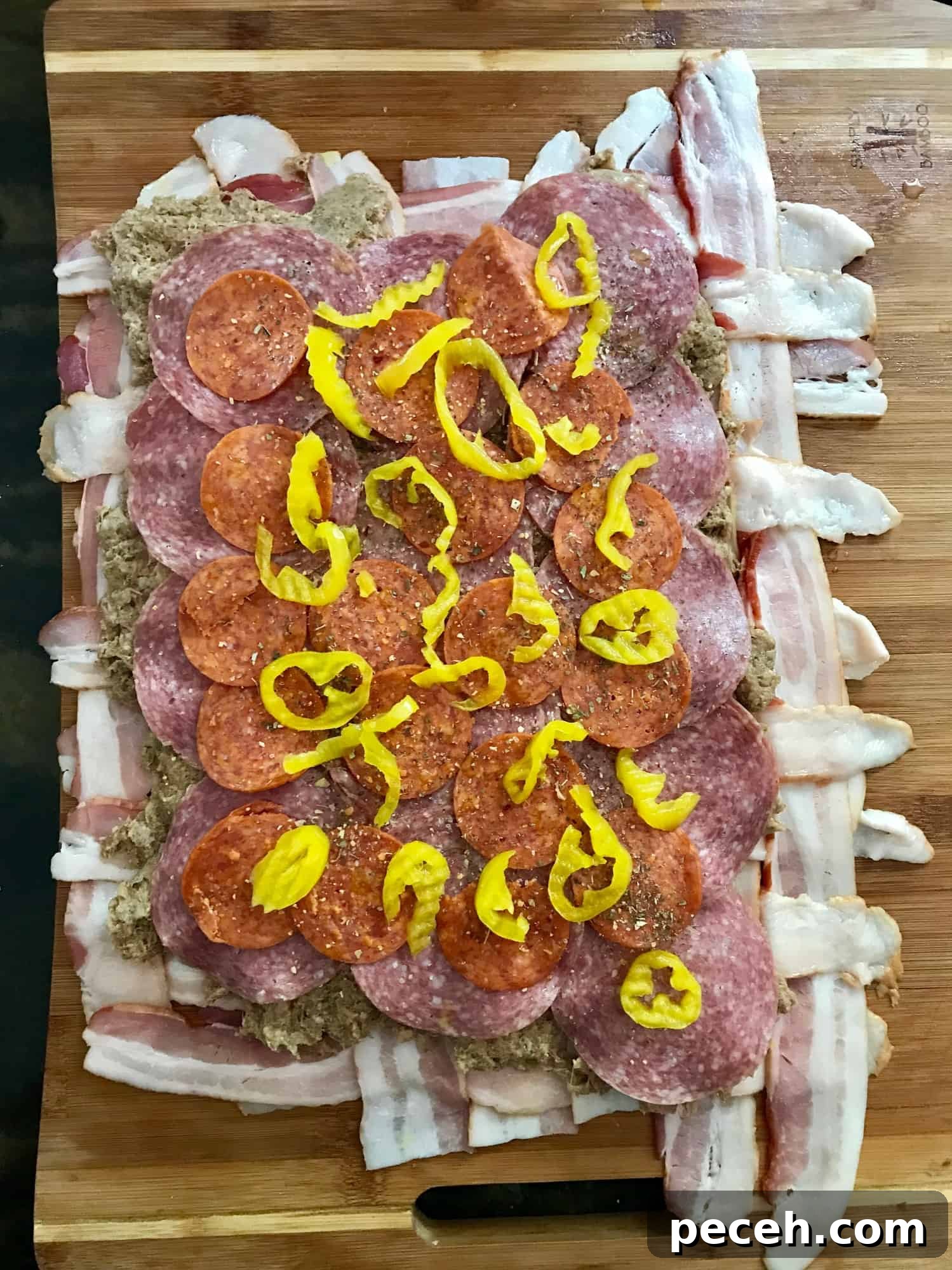 Bacon Explosion Pizza Roll: The Original Pizza Fatty Recipe 3 Bacon weave topped with meat and peppers on wooden cutting board overhead shot