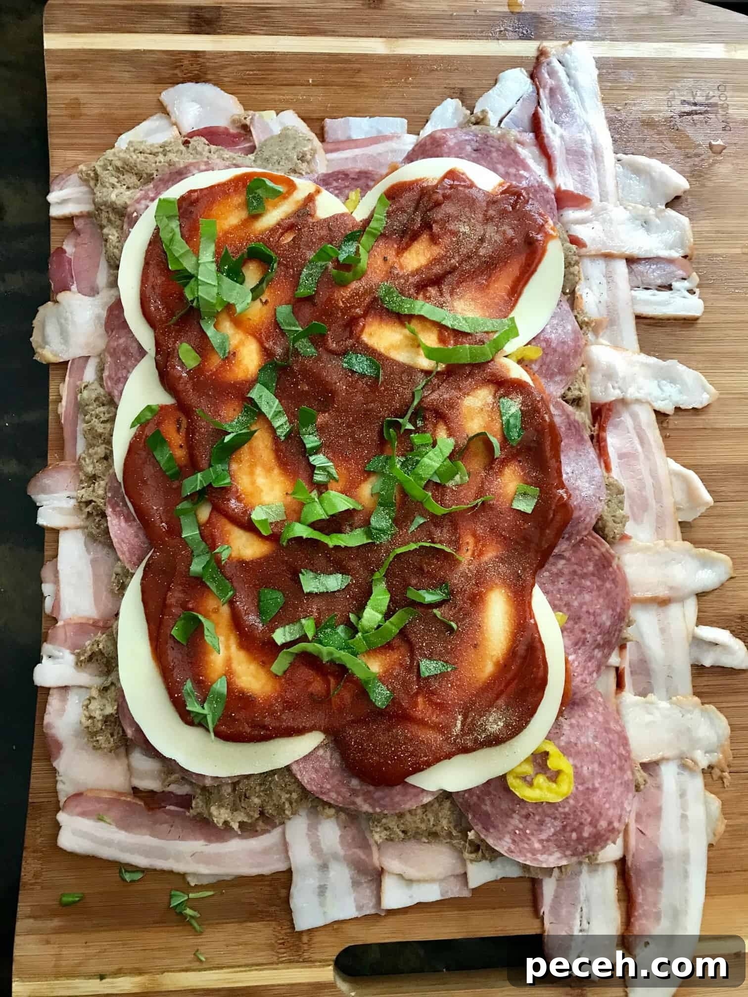 Bacon Explosion Pizza Roll: The Original Pizza Fatty Recipe 4 Bacon weave topped with cheese and sauce on wooden cutting board overhead shot